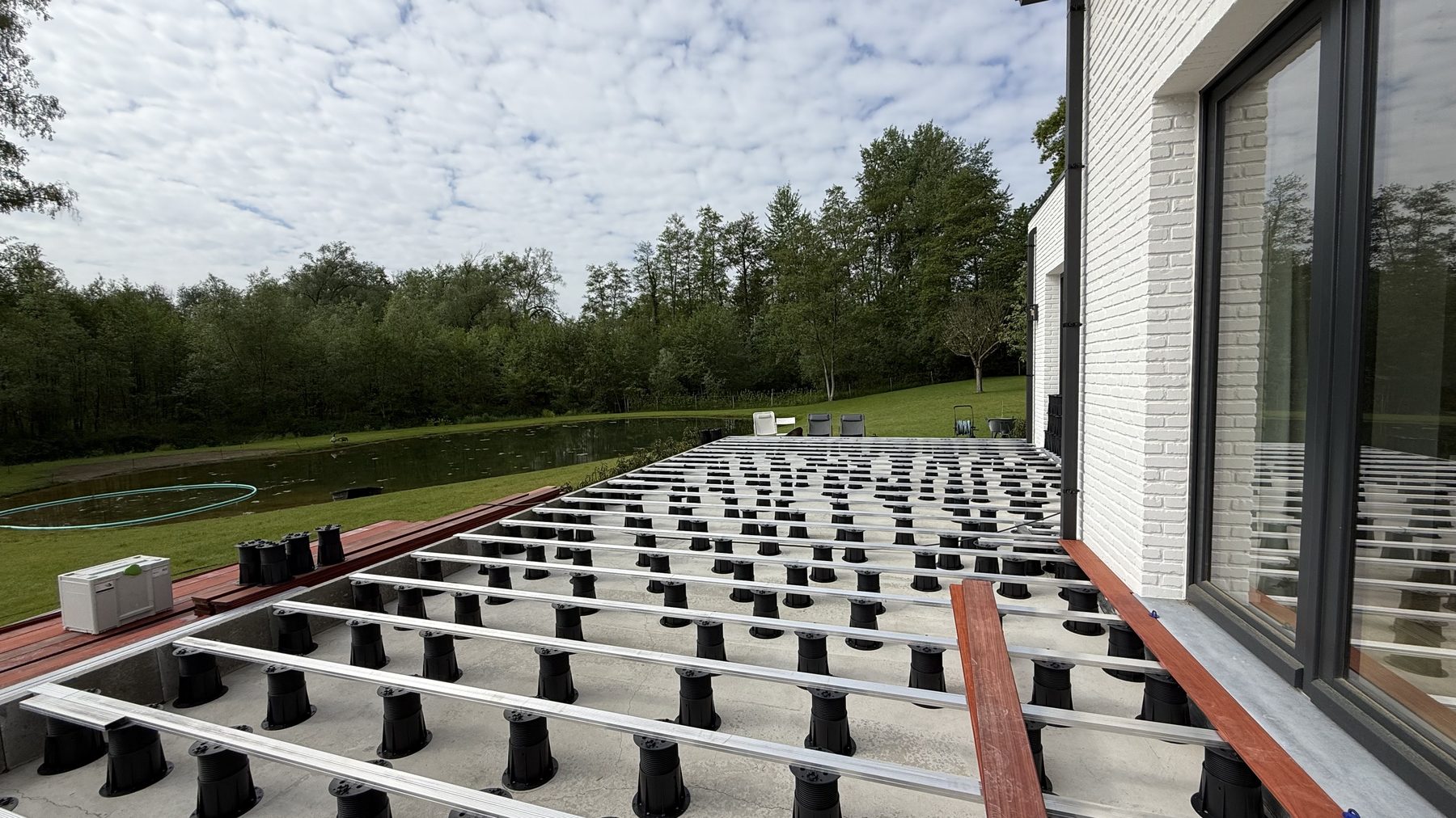 Avant : Terrasse en ipe : à gauche l'ossature aluminium sur plots, à droite les lames posées