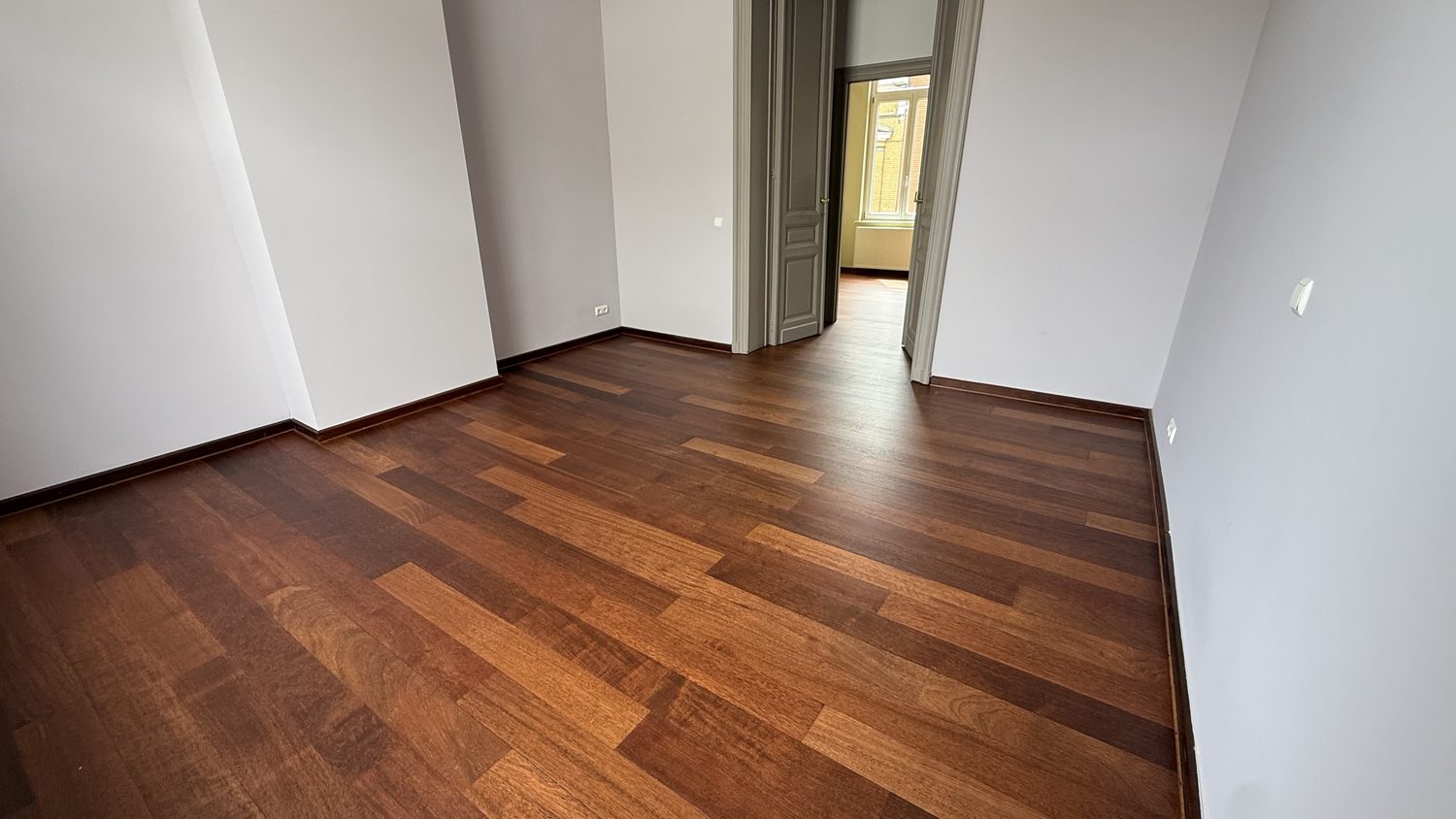 Pièce vide avec parquet foncé vitrifié