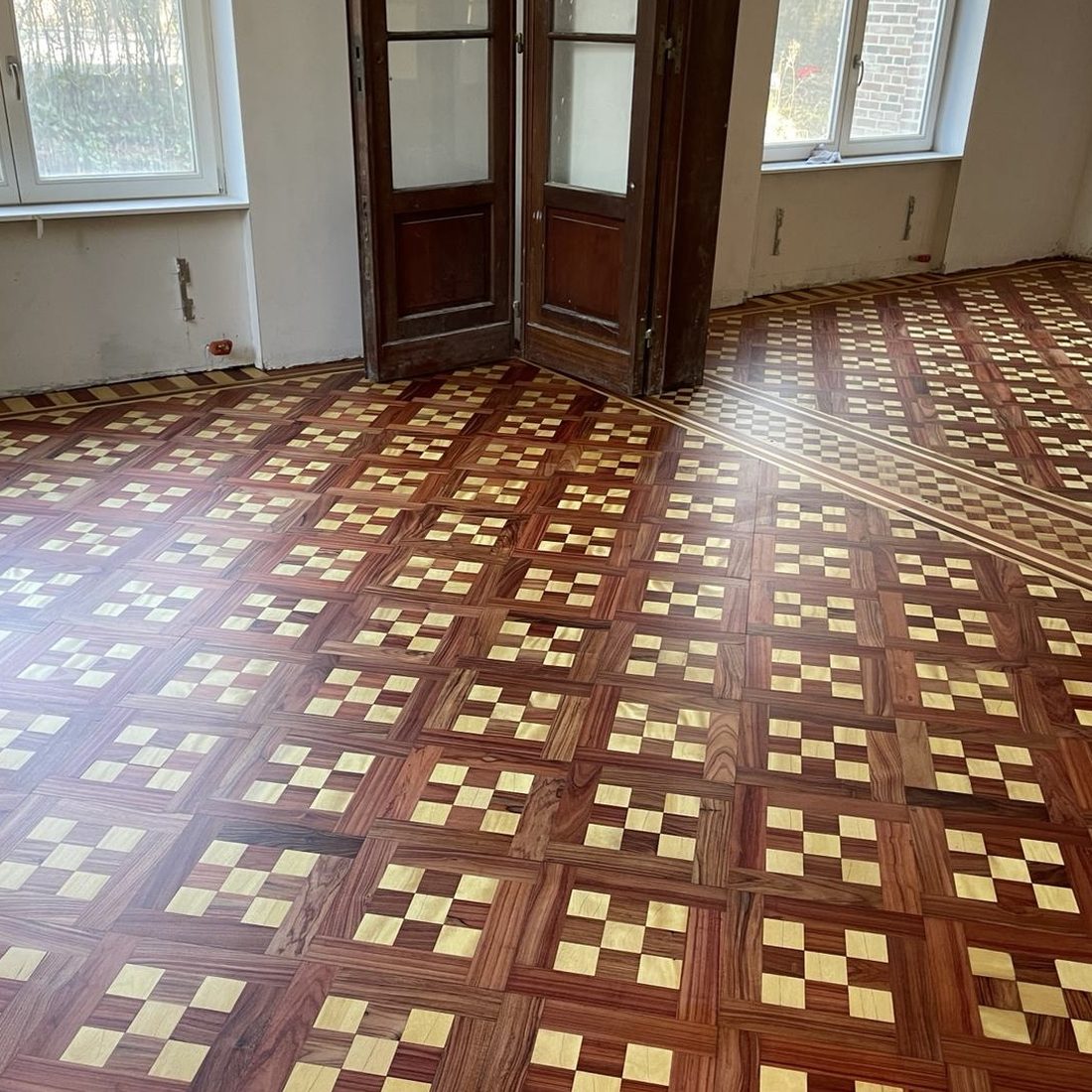 Parquet marqueté ancien à motif damier, après restauration