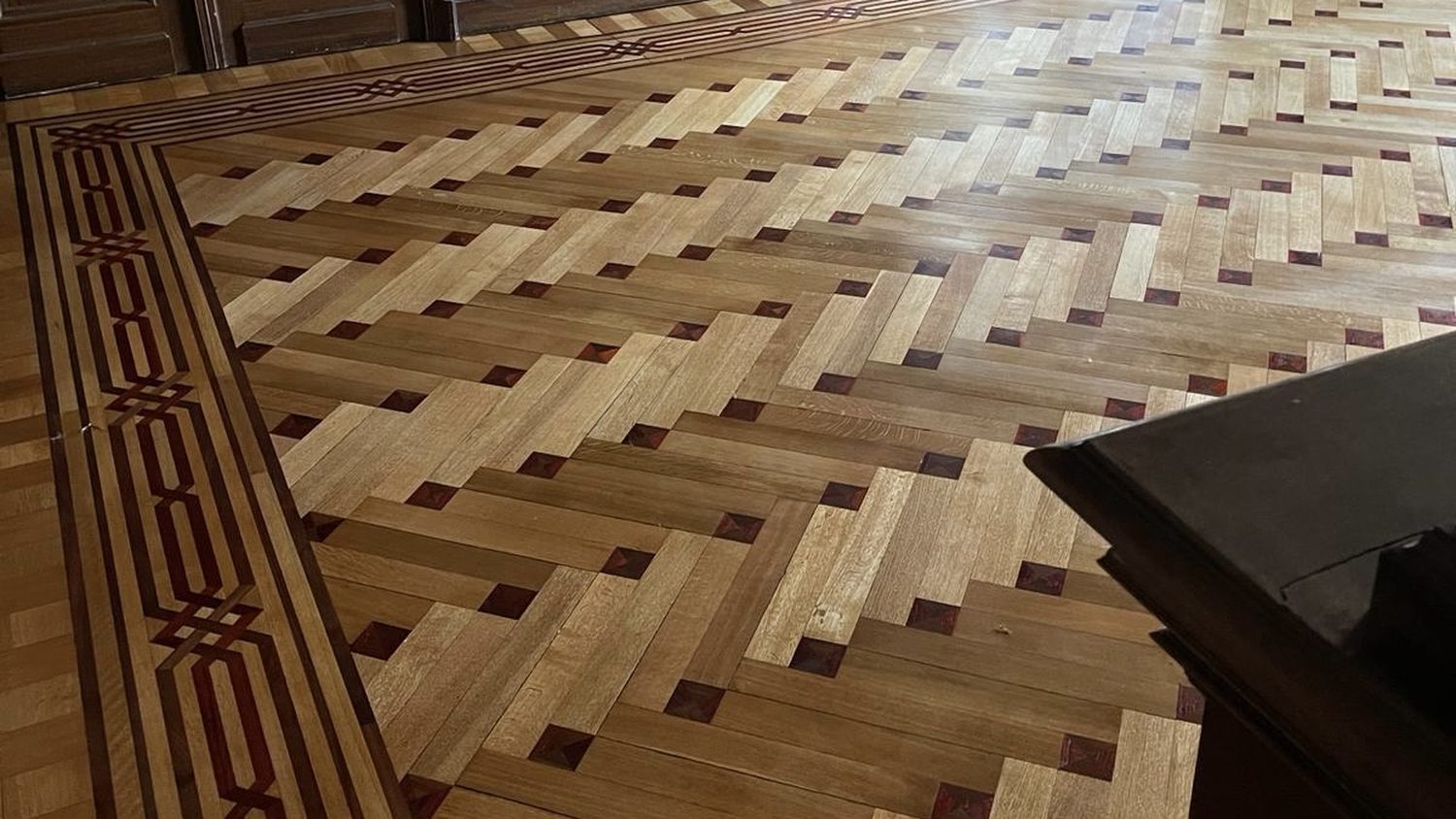 Parquet marqueté ancien à frise géométrique, après restauration