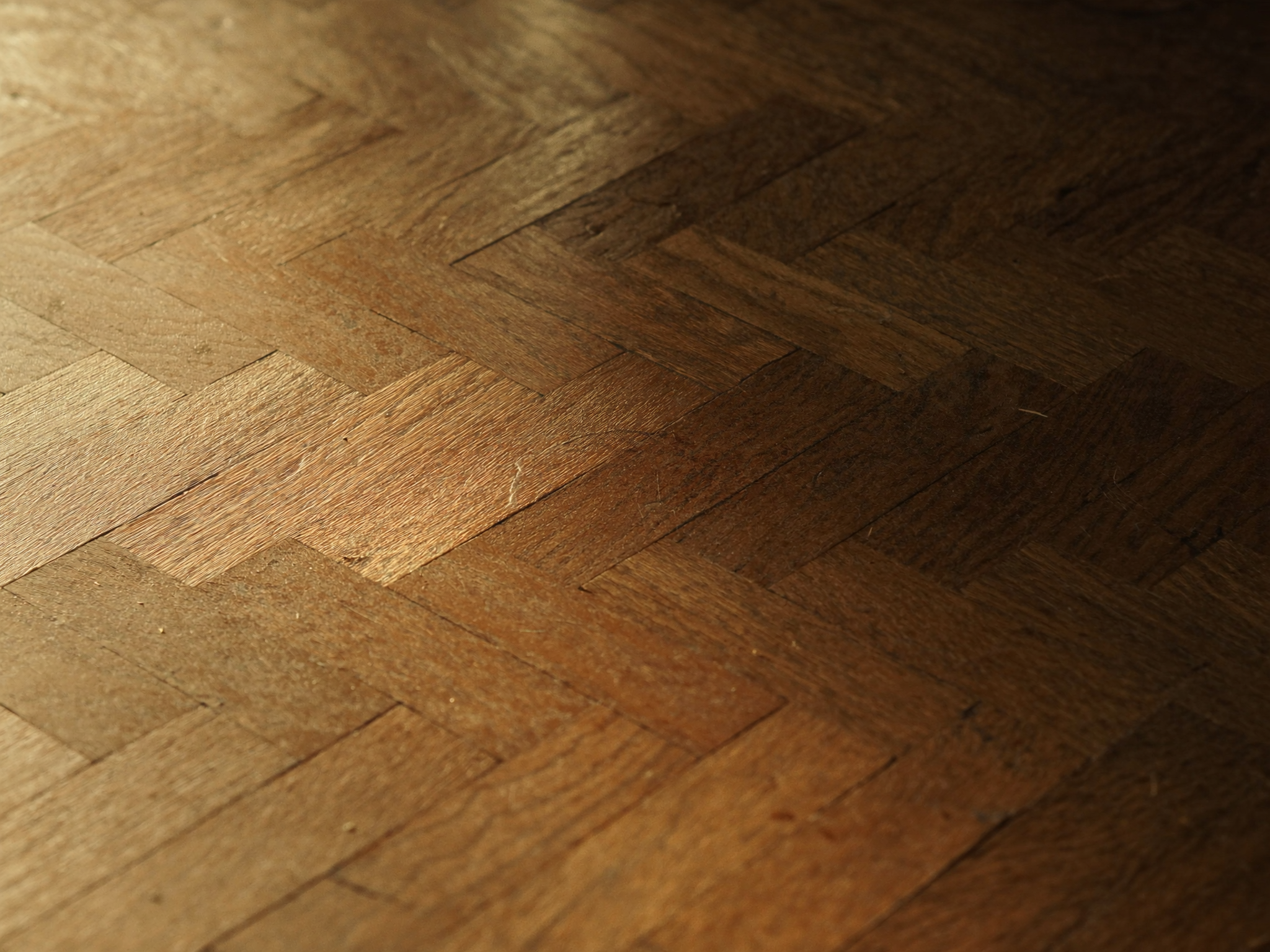Détail macro d'un parquet point de Hongrie en chêne avec lumière rasante