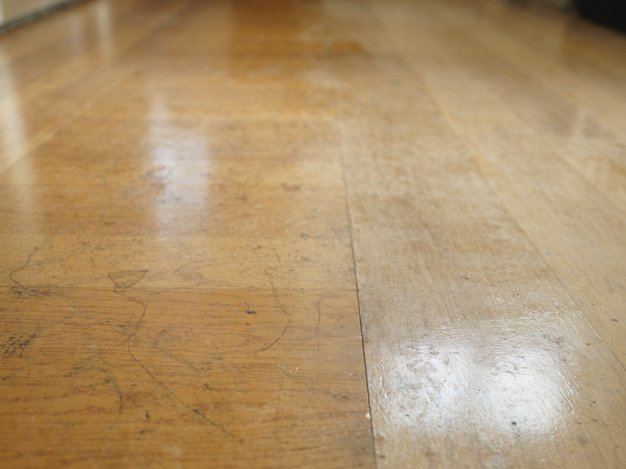 Parquet en cours de rénovation, contraste avant/après ponçage et vitrification